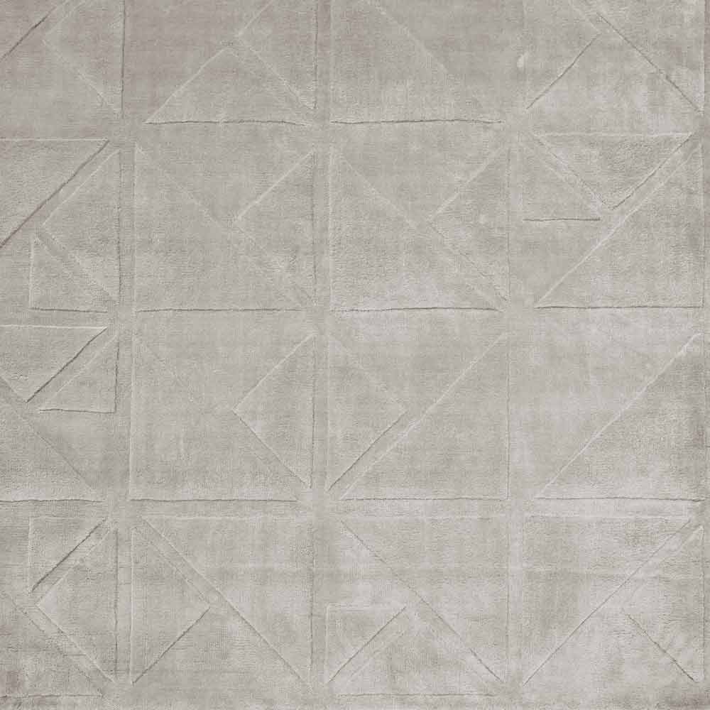 Fliesenboden oder -wand mit geometrischen Formen wie Dreiecken und Vierecken in verschiedenen Grautönen, die ein symmetrisches und interessantes Muster bilden