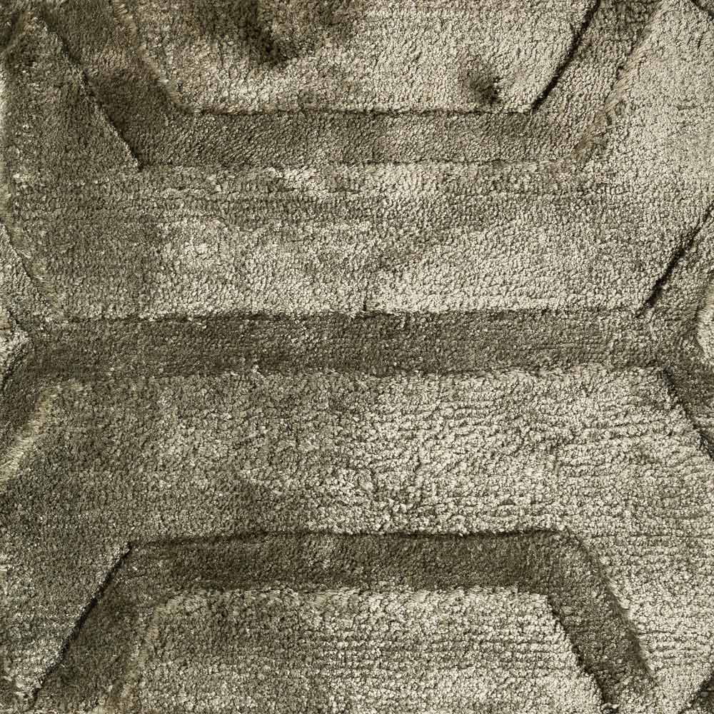 Teppich Liva 200x300 (olive) Nahaufnahme einer strukturierten Oberfläche mit einem Muster, das ineinandergreifenden Formen oder Ziegeln ähnelt. Das Muster hat Tiefe und Schatten, was eine dreidimensionale Qualität suggeriert.