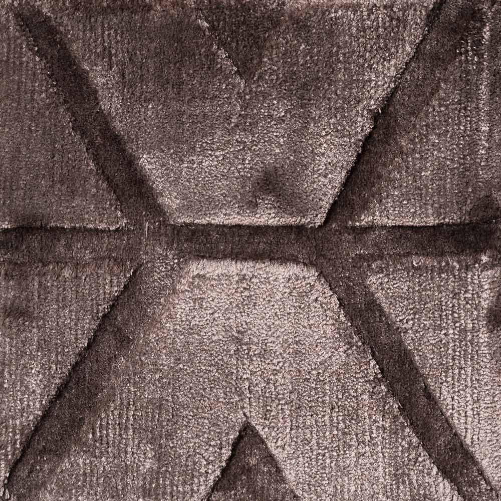 Geometrisches Design mit erhabenen Dreiecken und Trapezen, das einen dreidimensionalen Effekt auf einer weichen, strukturierten Oberfläche erzeugt.