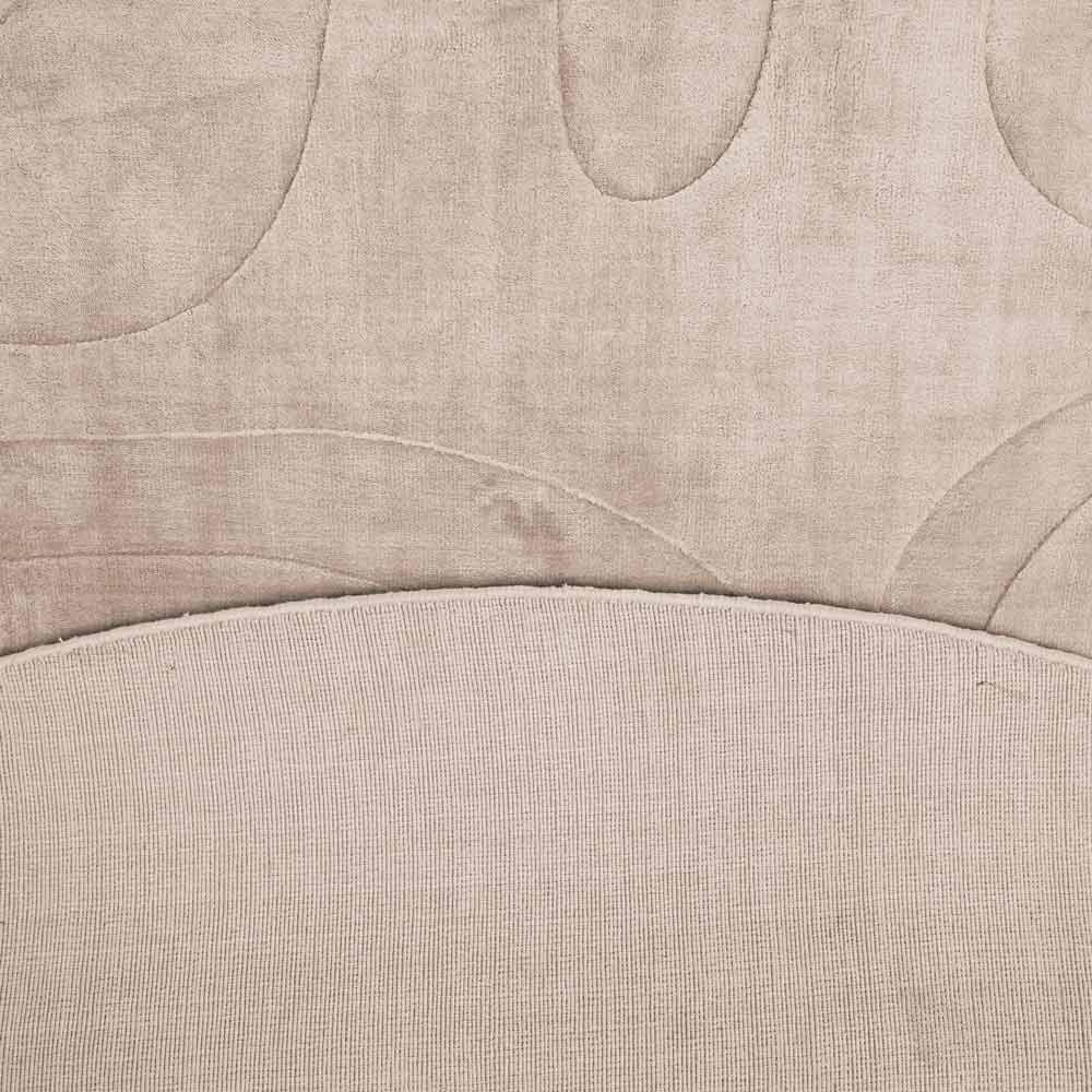 Detailaufnahme eines Möbelstücks mit beige Stoffpolsterung und abstraktem, ornamentalen Muster.