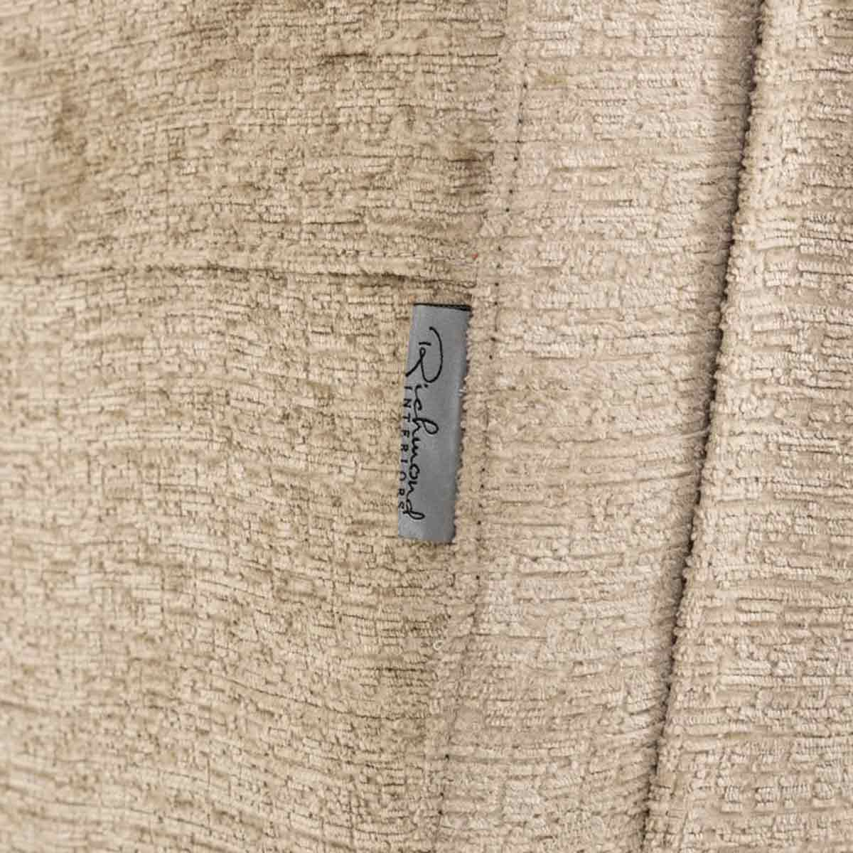 Relaxsessel Denvi desert fusion (Fusion 109 desert) Das Bild zeigt eine Nahaufnahme des Relaxsessels Denvi (Fusion 109 desert). Die sandfarbene Polsterung und das Richmond-Logo sind deutlich sichtbar.