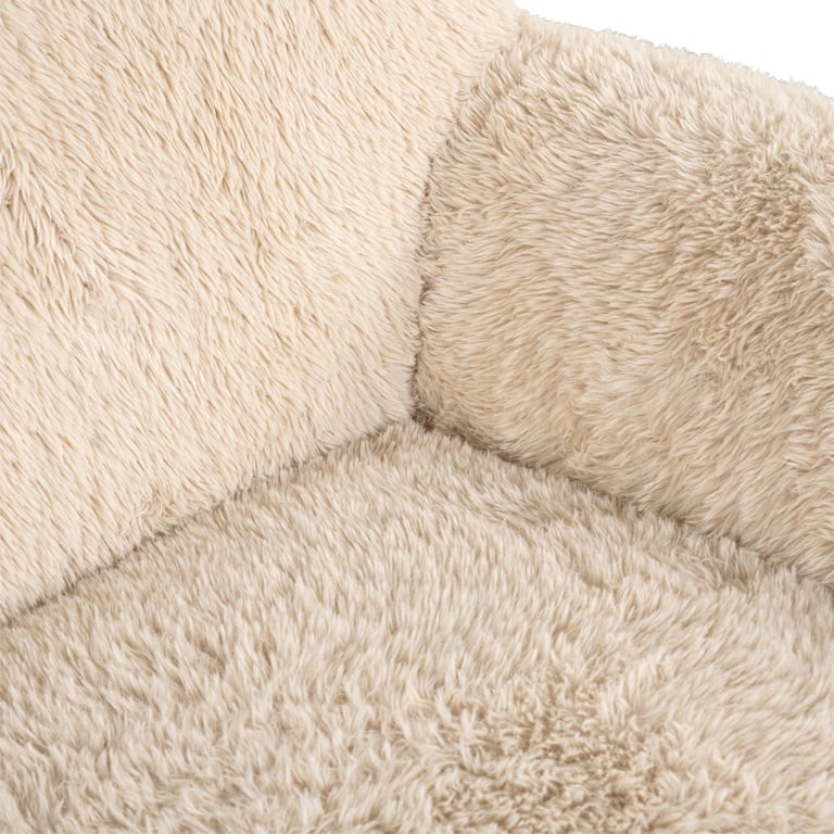 Nahaufnahme eines beigen, flauschigen Stoffes, wahrscheinlich von einem Möbelstück wie einem Sofa oder einem Kissen. Die Textur wirkt weich und komfortabel, mit deutlich hervortretendem Flor des Stoffes.